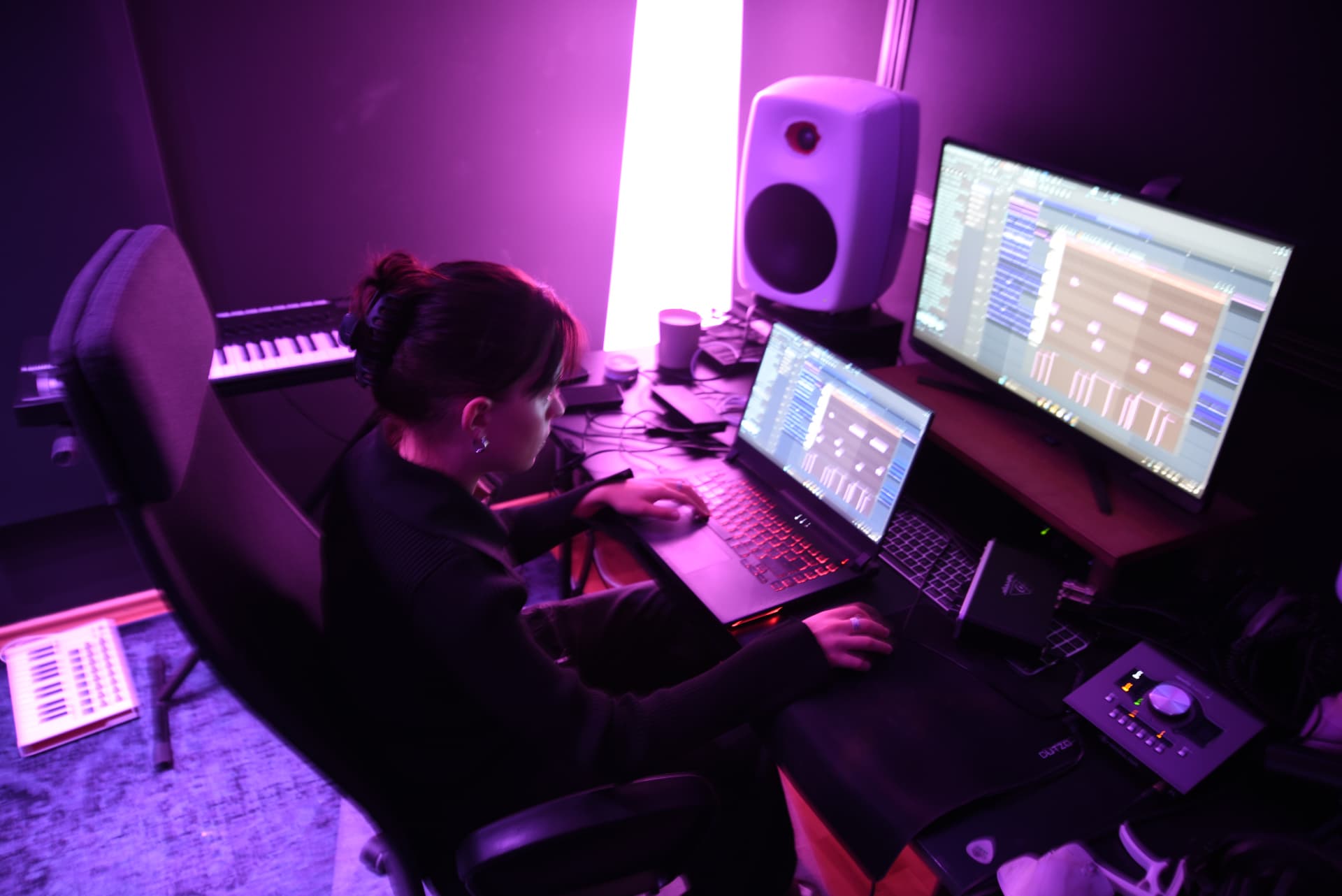 Working on a production session at the studio desk in purple light
